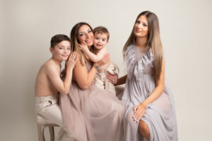 family of mum with her children, all wearing co-ordinated neutral outfits, by a family photographer in Hull