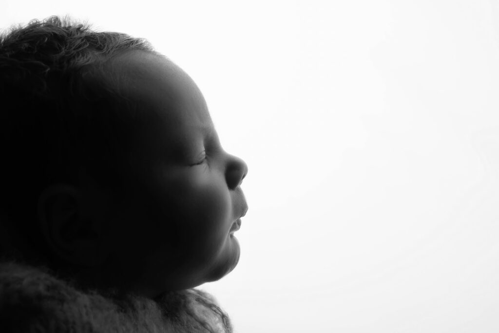 black and white image of a baby's profile with a white background