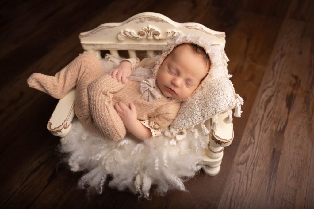 baby girl asleep in a day bed with white fluffy layers