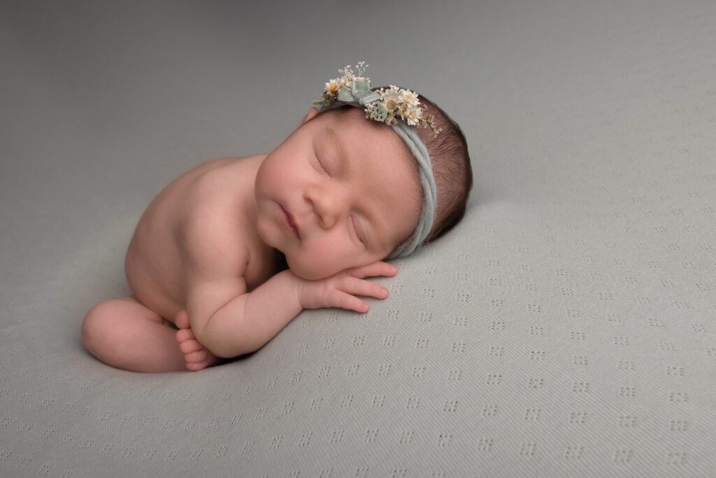 baby girl asleep on a sage green blanket by Hull newborn photographer