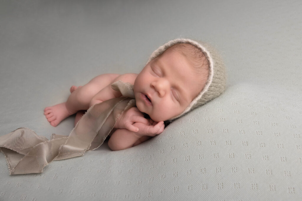 Newborn baby peacefully sleeping during a professional photoshoot at Kerry Jones Photography in Hull.