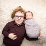 baby boy with older brother lying down by Hull newborn photographer